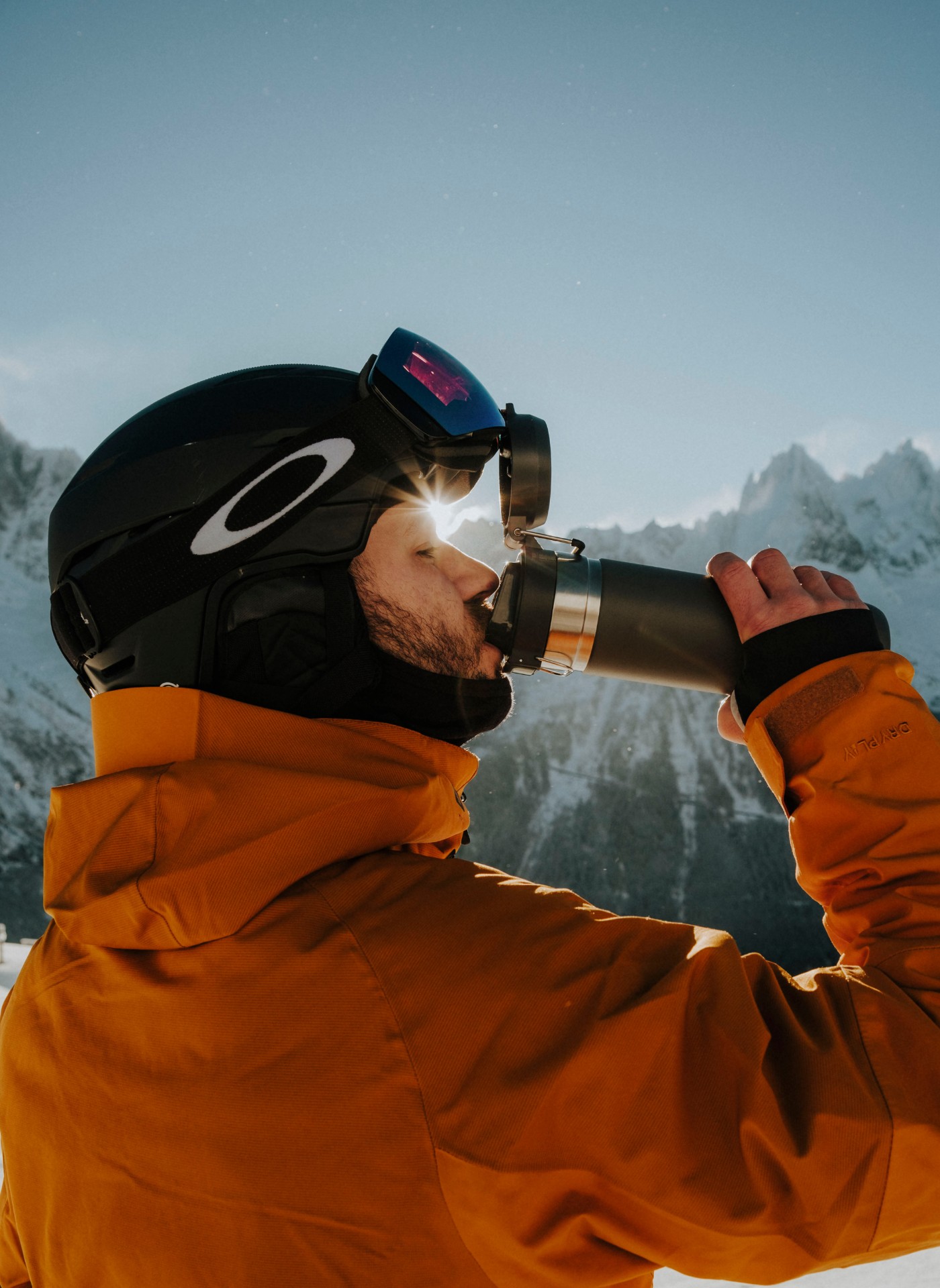 Man drinking from Stanley flask in ski gear