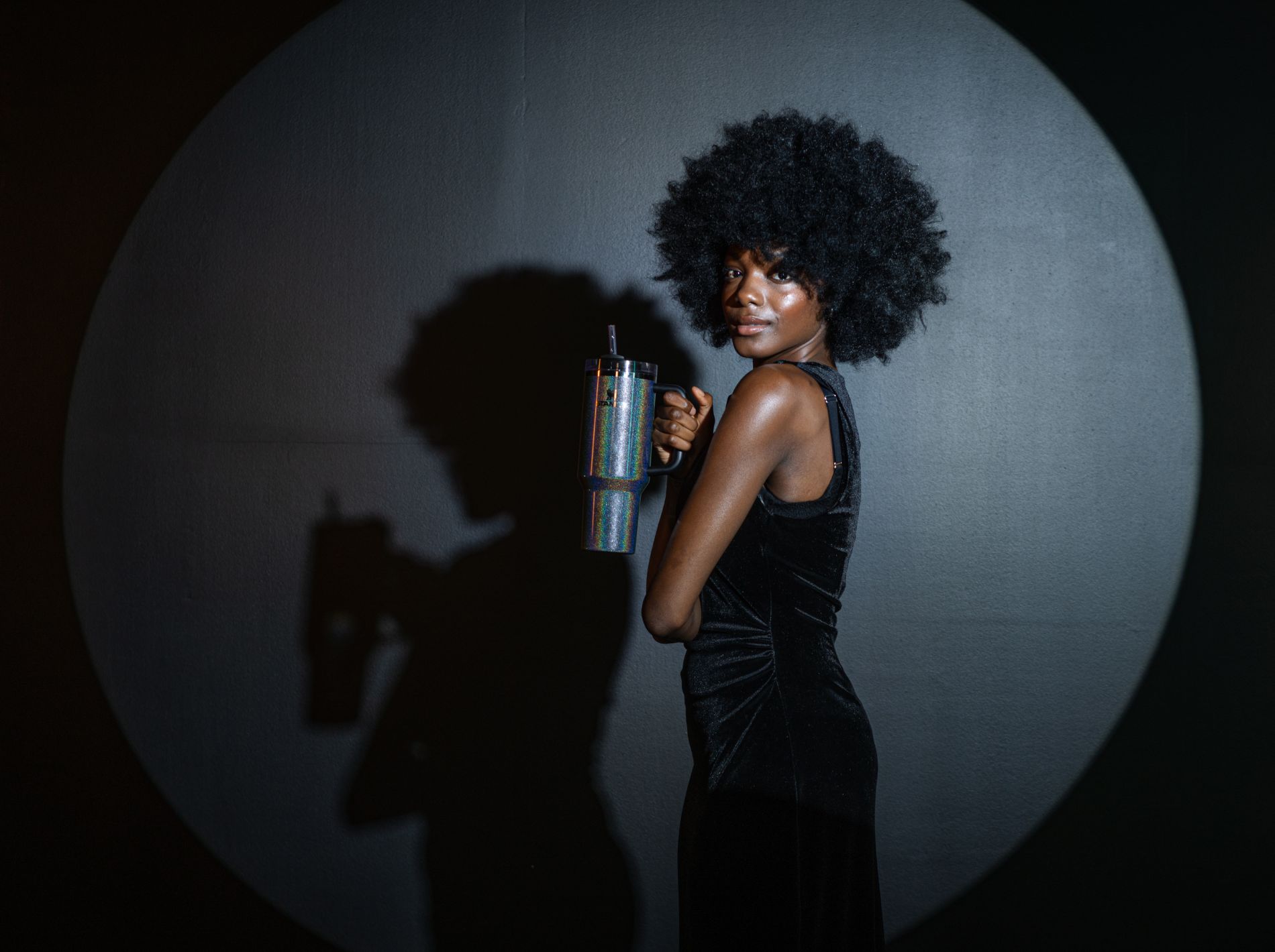 Female model standing i the spotlight holding the Midnight Glitz Quencher